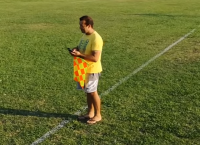 Επόπτης με σαγιονάρα και κινητό στο γήπεδο