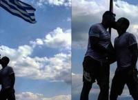 Αξιωματικός της Ελληνικής Αστυνομίας φιλιέται με μετανάστη μπροστά στην ελληνική σημαία και γίνεται χαμός από αντιδράσεις