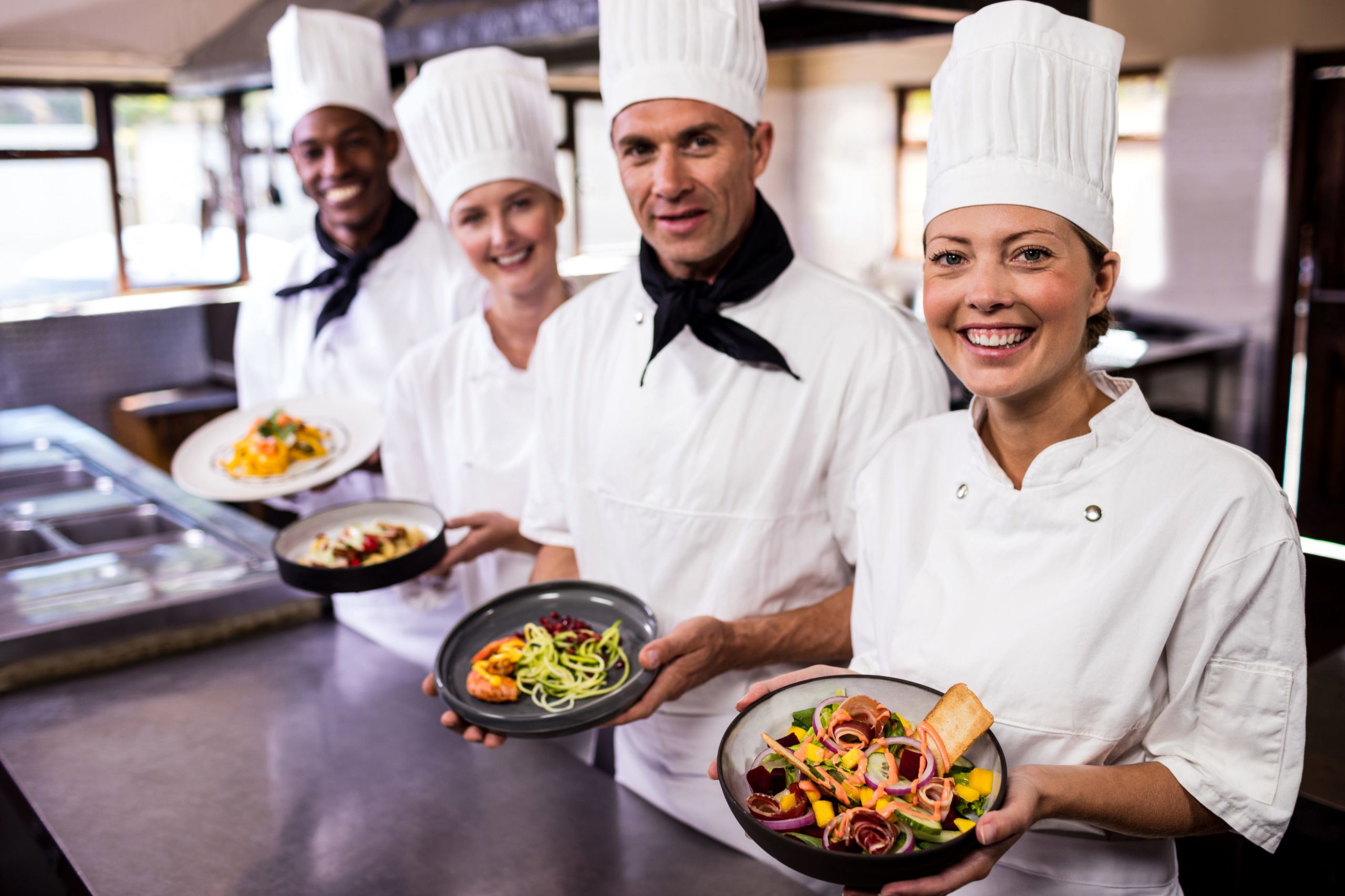 Group Of Chefs Holding Plate Of Prepared Food In 62MPWNQ E1563435447331 Scaled 